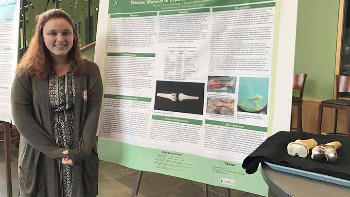 Anthropology student Hannah Kruse stands in front of the poster she presented at the annual Bioarchaeology Northeast Regional Dialogue conference at Quinnipiac University. 
