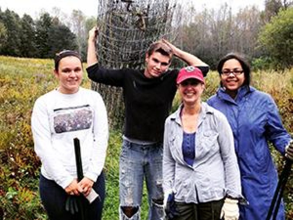 Students and their professor setting up an outdoor dig site