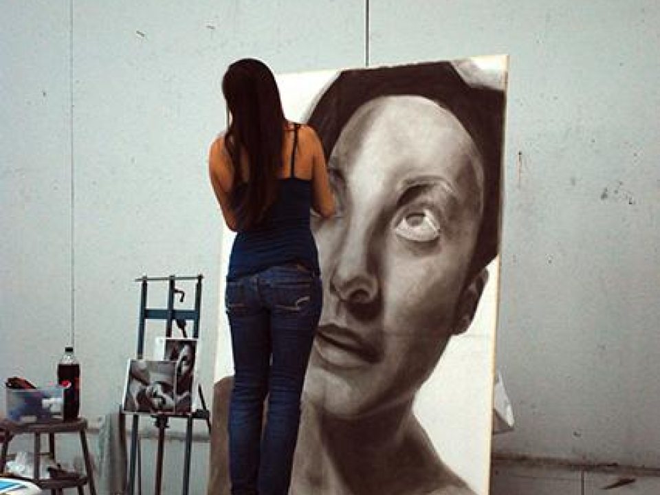 A student working on a large portrait