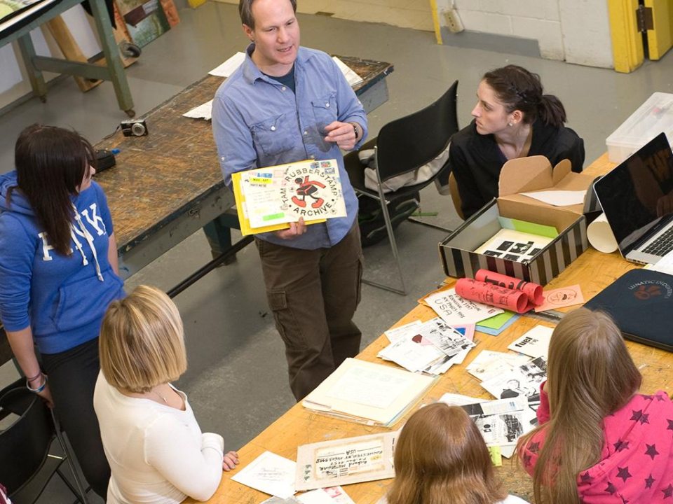 A professor and students in an art studio