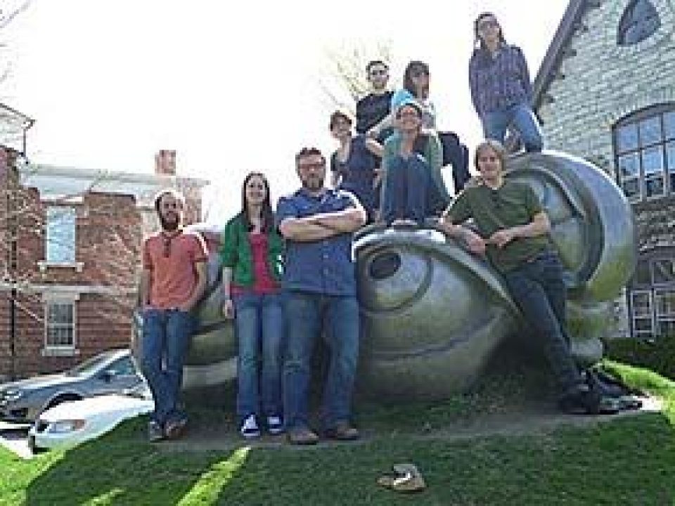 A group of students posed around a sculpture