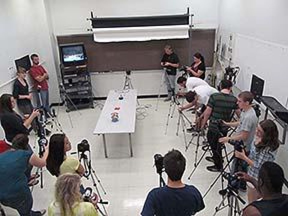 Students with cameras on tripods in a photography studio