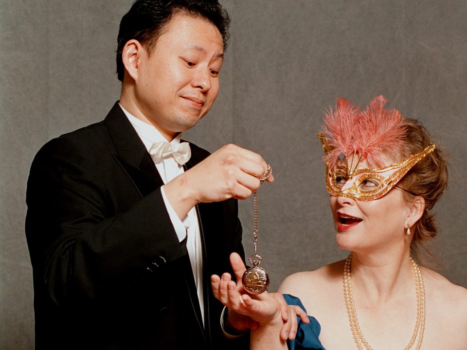 Oliver Lo holds an ornate watch over the open hand of a female companion.