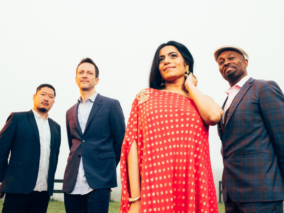 The members of American Patchwork Quartet stand together outdoors.