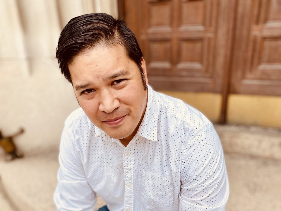 SUNY Oswego Artist-in-Residence Al Abonado sitting on a stoop.