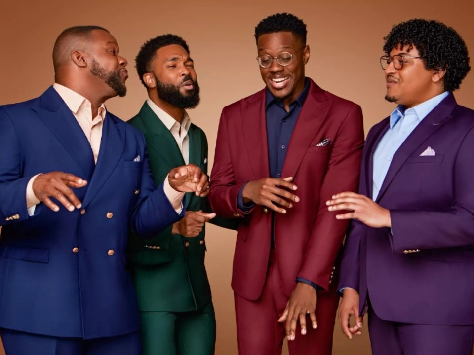 The four members of Kings Return singing together against a brown background. 