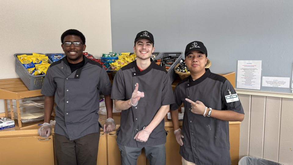 Three student workers standing at the Deli station. 