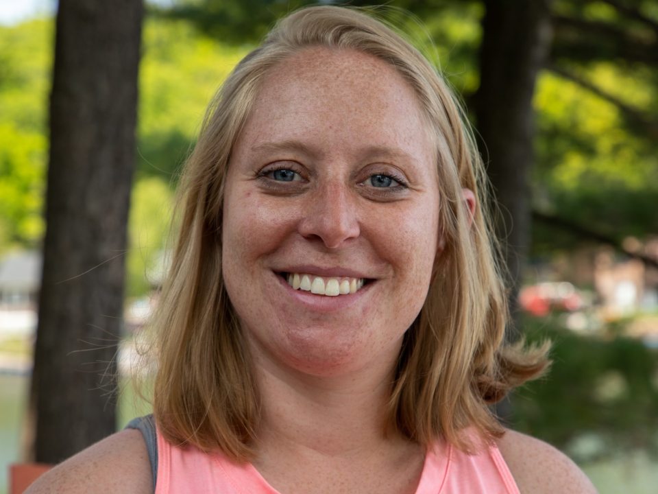 Headshot of Ali, wearing a pink shirt. 
