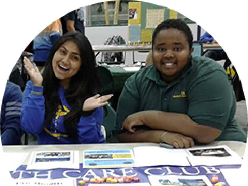 Two students hosting a table for a club