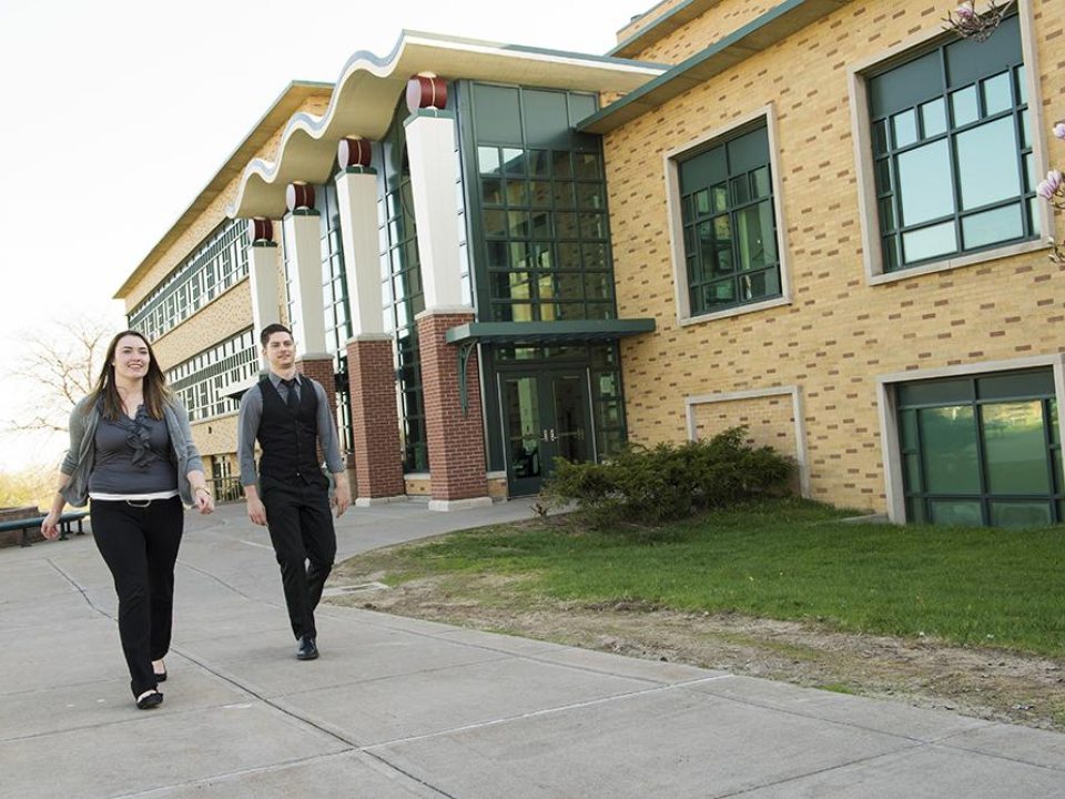 Two students walking outside of Rich Hall