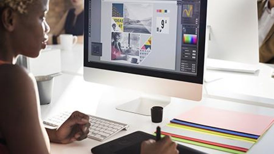 A student looking at a graphic design program on a computer (Adobestock)