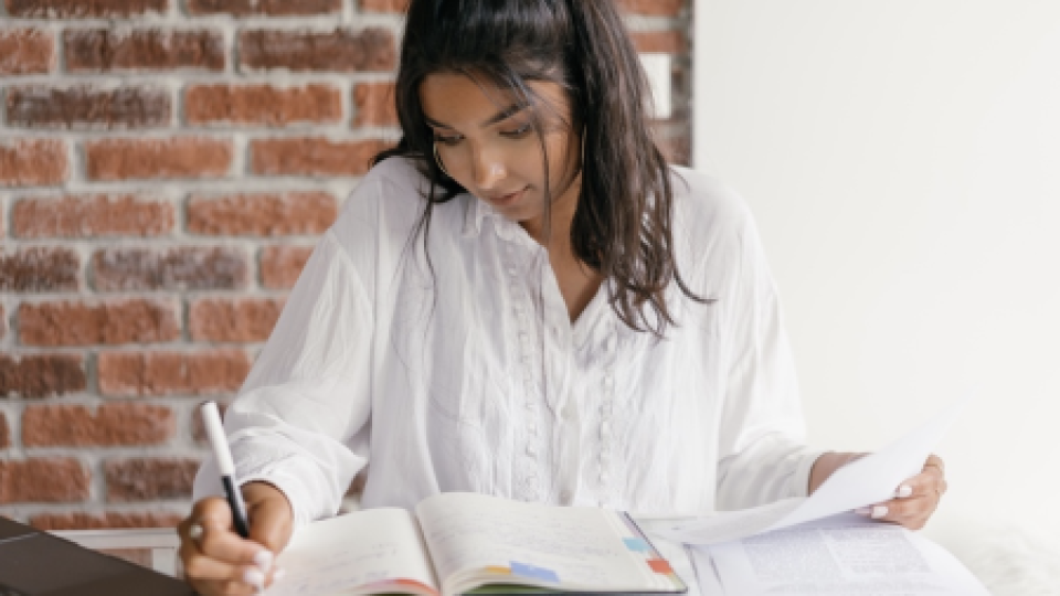 A woman writing in a workbook