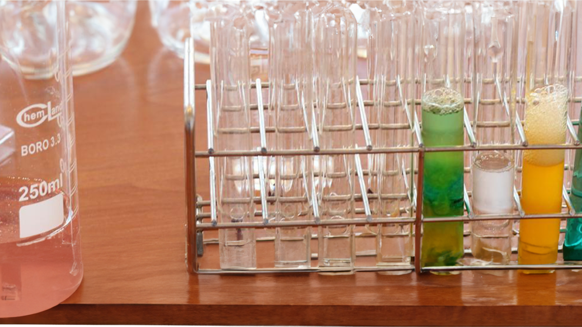 A laboratory bench with a beaker and test tubes containing colorful liquids.