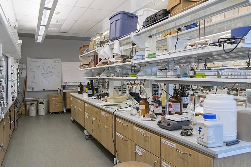 An empty chemistry laboratory with equipment and supplies on the benches.