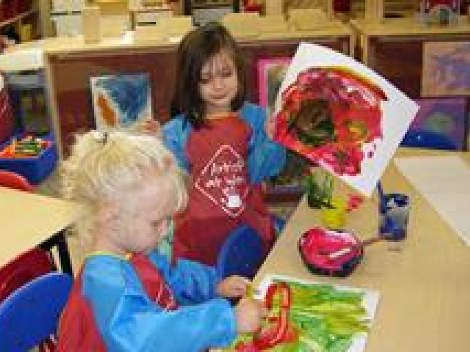 Two young girls finger painting