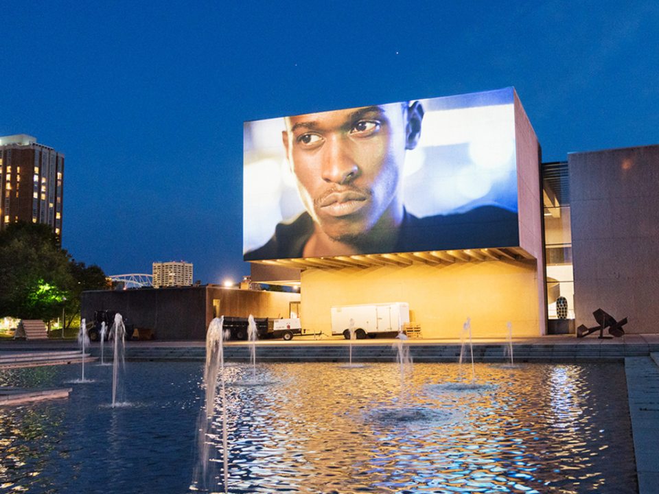 A large fountain with a large billboard screen in the background