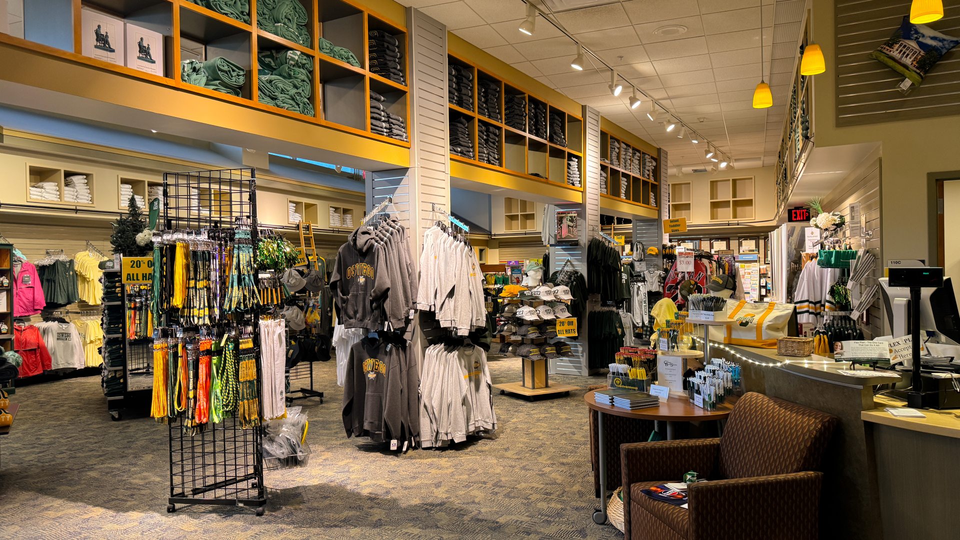 College store interior featuring rows of branded apparel, textbooks, and school supplies neatly displayed. Bright, inviting atmosphere with students browsing the aisles.