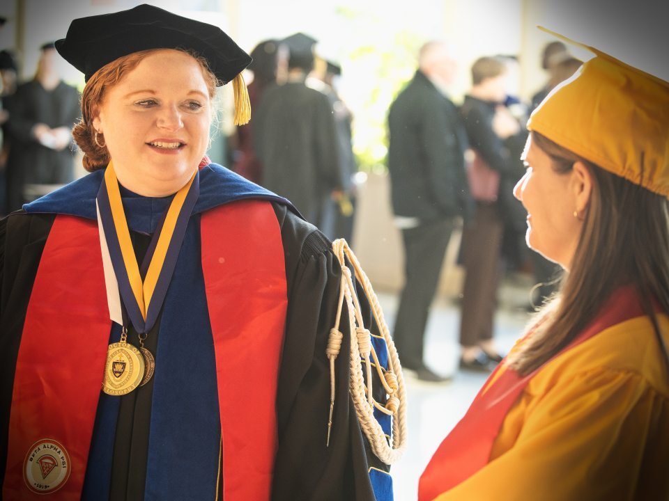 Commencement participants don their academic attire for the processional