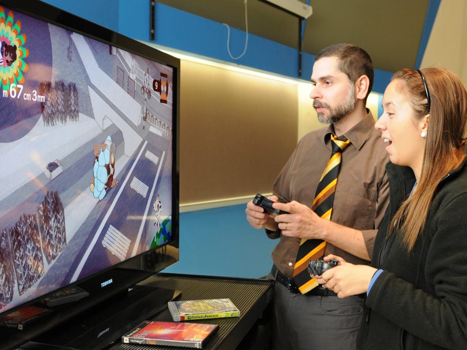 Two students playing a game on tv