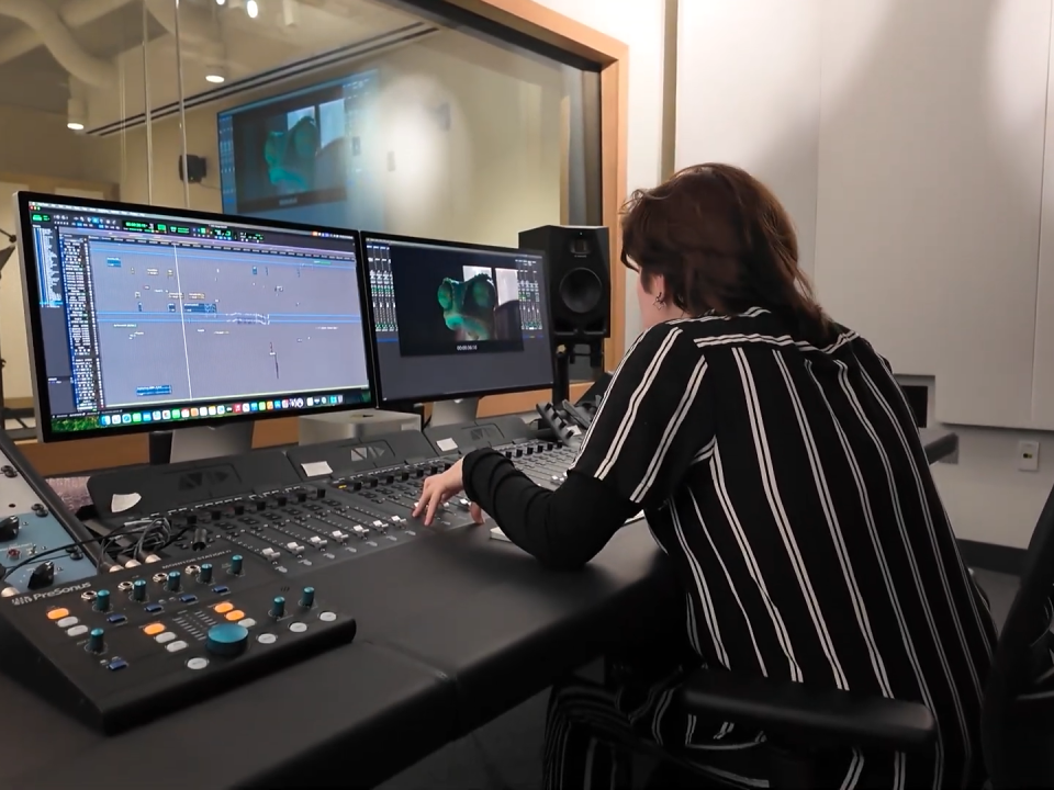 Student working on audio mixer in Foley Control Room 