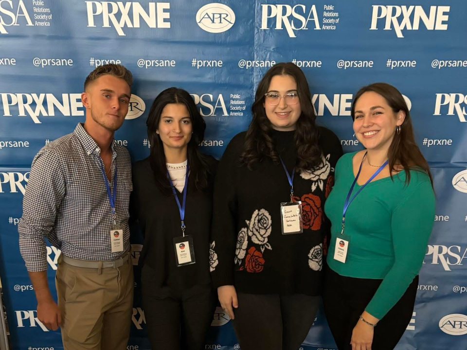 PRSSA Students in front of step and repeat at a PRSA conference