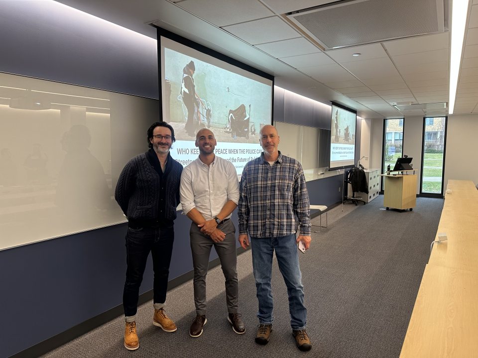 Here is clean, accessible alt text:  Three individuals pose side by side in a classroom setting. From left to right: Criminal Justice Professor Matthew McCleskey, guest speaker Forrest Stuart, and Criminal Justice Professor Roger Guy.