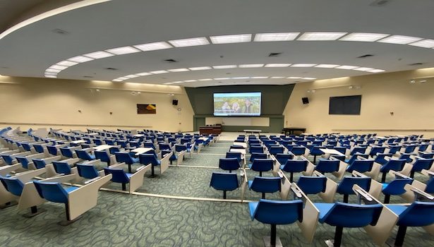 Photo of the back of the classroom from the center. Including the screen/podium/seats.