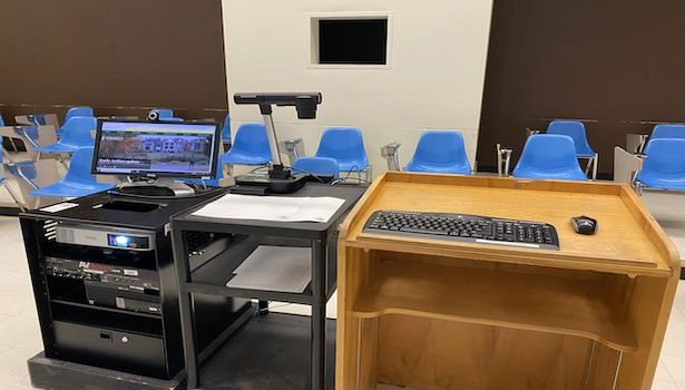 Photo of the podium equiptment in the room. Including Cart PC. Document Camera, projector and keyboard/mouse.