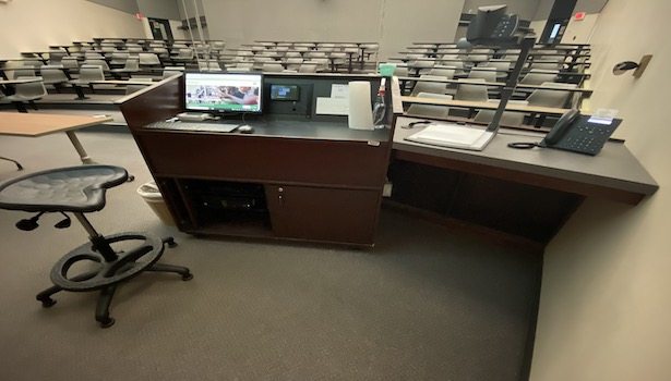 Photo shows the podium in the room including PC, Doc Cam, Blu Ray and touchscreen.