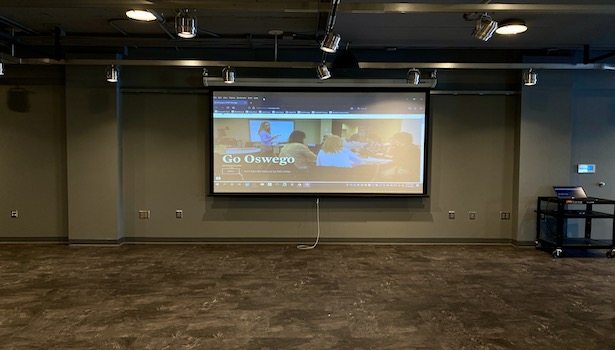 Photo showing a picture of the center projection screen including a cart.