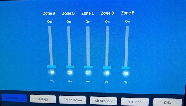 Photo shows the touch panel where someone would control the lights. Located to the right of the center projector screen.