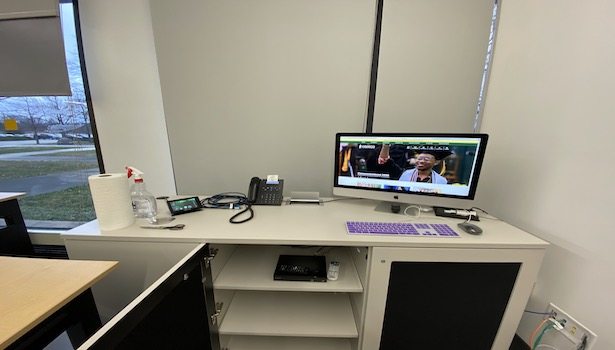Photo of the professor podium in the room. Showing the professor MAC and other technology