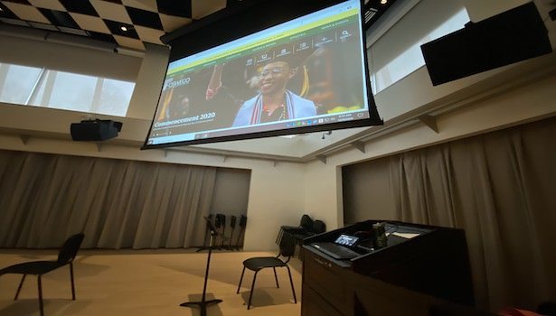 Photo of the classroom podium with the projector screen in the background.