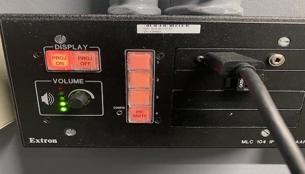 Photo showing the Extron panel in the room where laptop can be plugged in, volume and display on and off buttons.