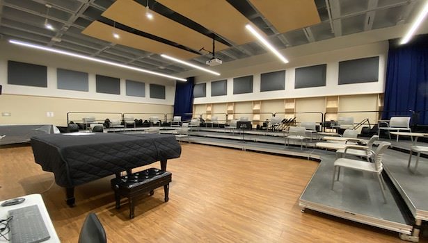 Photo of the classroom showing risers, chairs and the classroom piano.