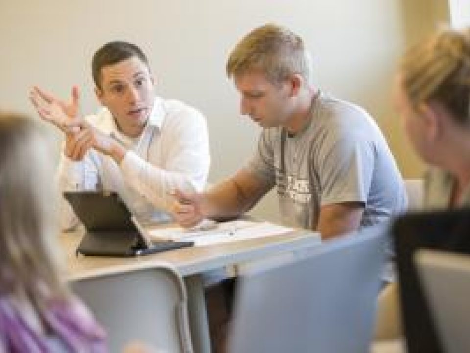 Students sitting at a table discussing something