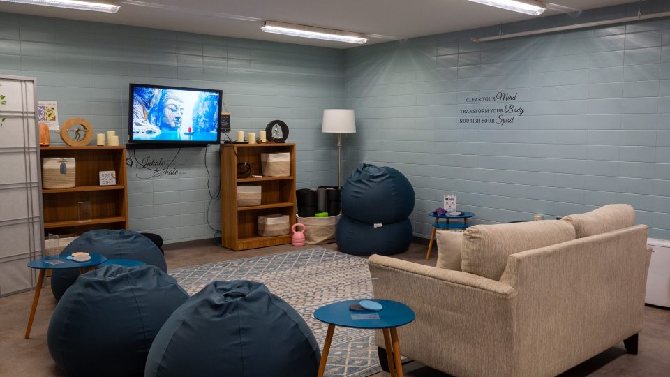 A wide view of the Harmony Room with multiple blue bean bags, a tan couch, and other various decor.
