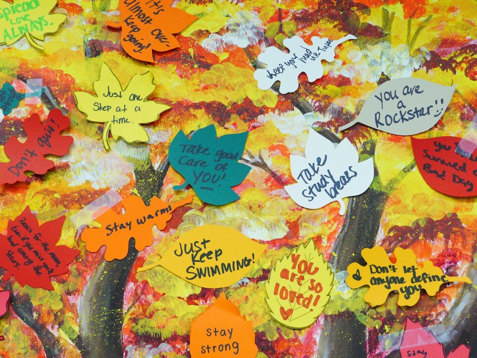 Painting of a tree with sticky note leafs. Positivity notes are written on them.