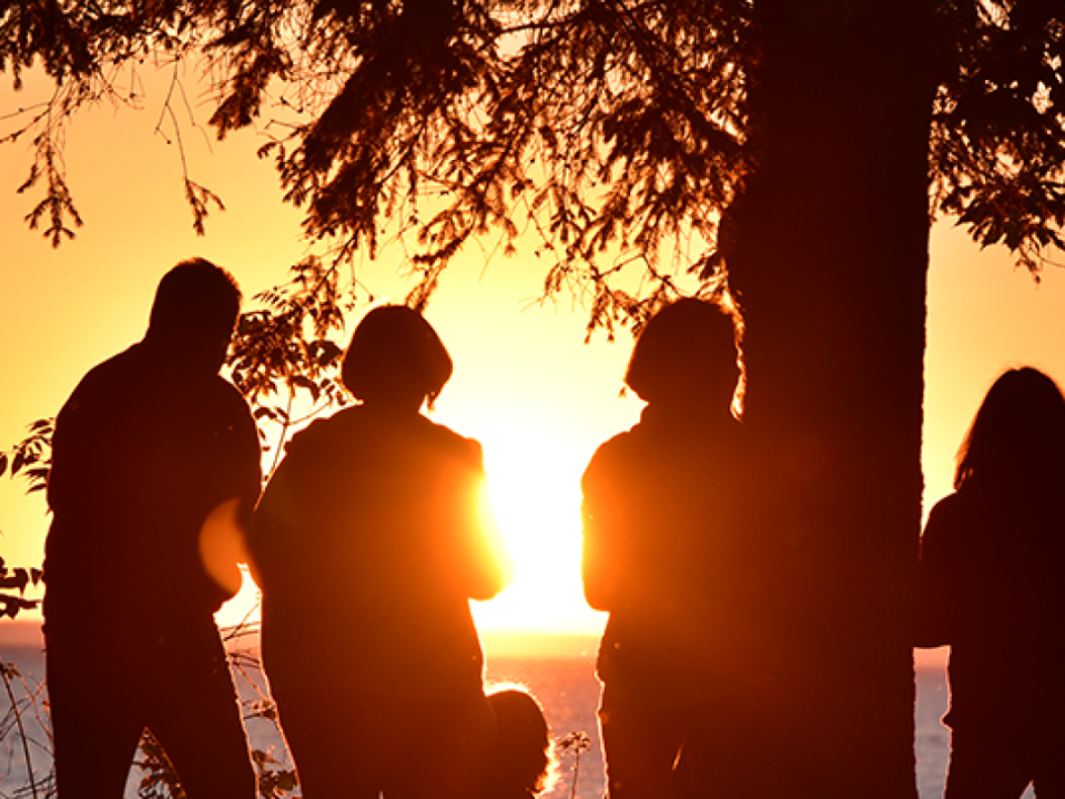 A group of students looking at the sunset over the lake