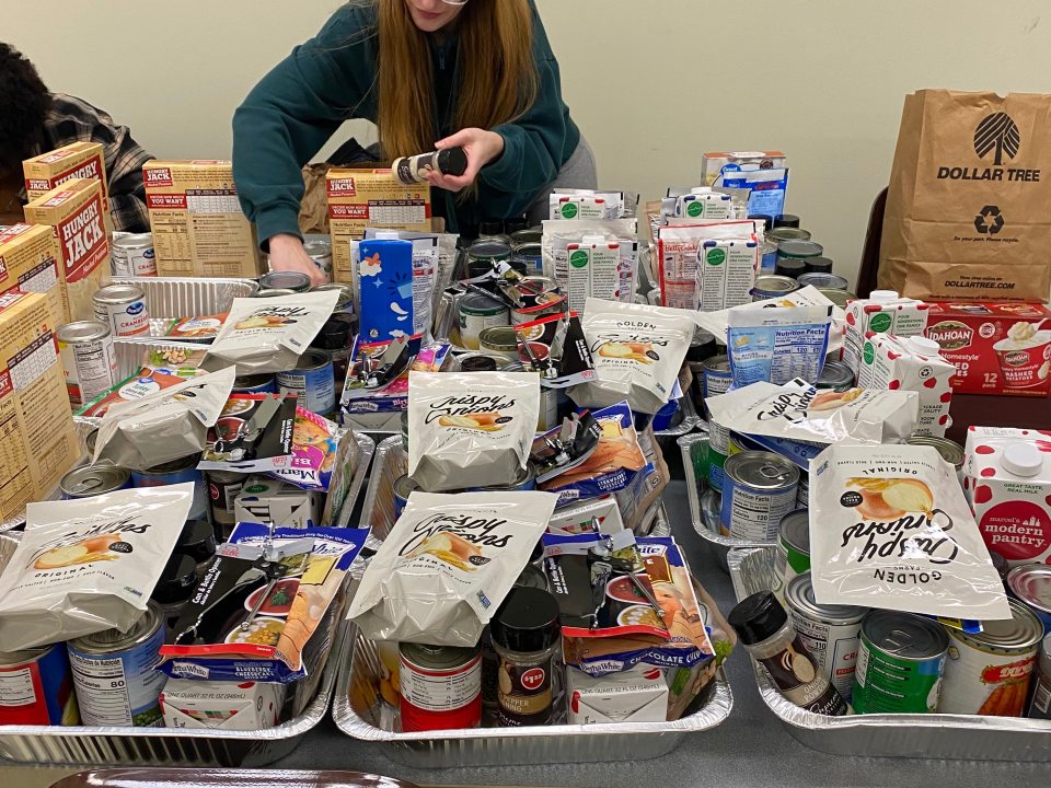 Student putting together Thanksgiving Baskets. 