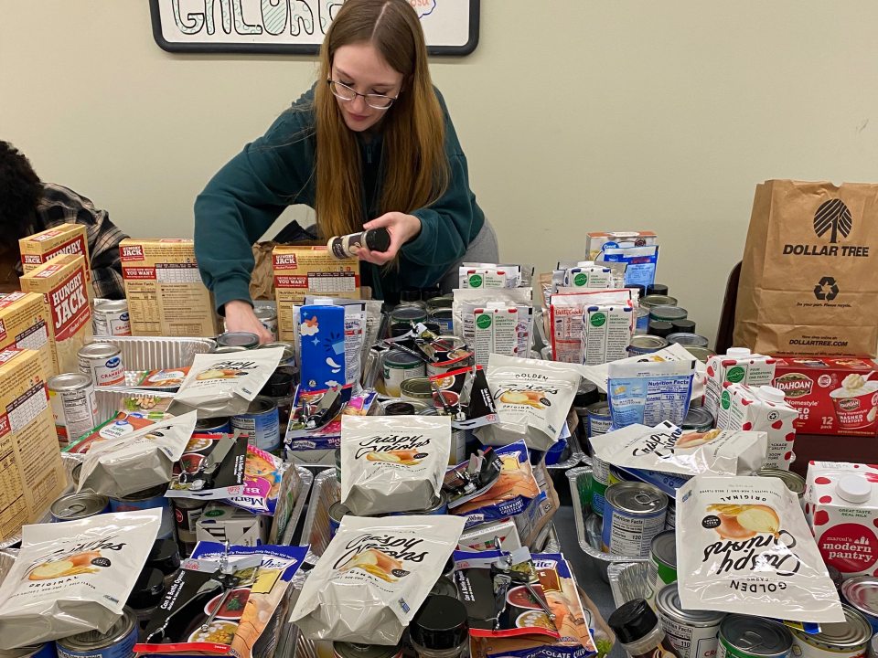 Student putting together Thanksgiving Baskets. 