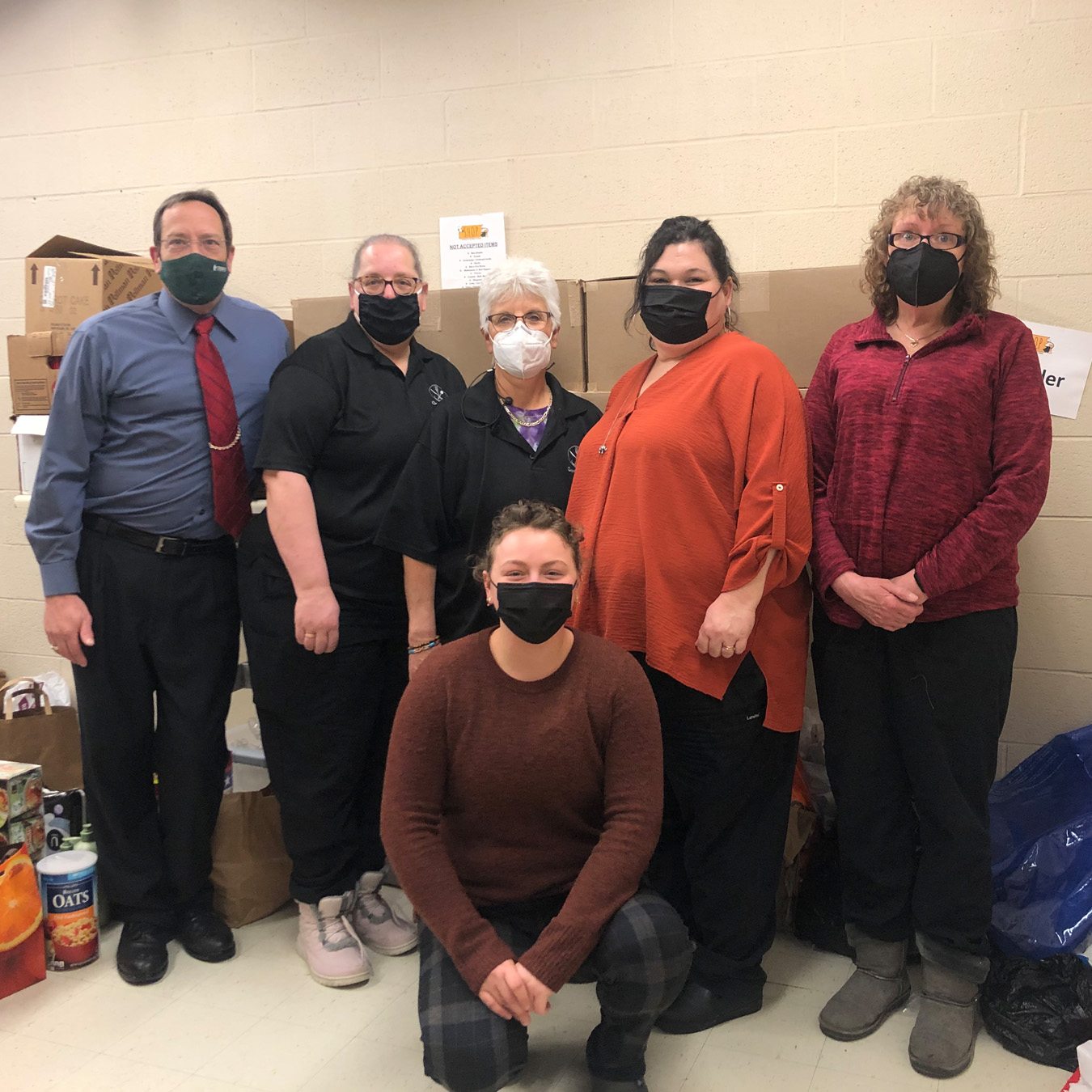 Auxiliary Services posing for a photo with Helena (former SHOP Food Pantry Coordinator) and their donations at SHOP
