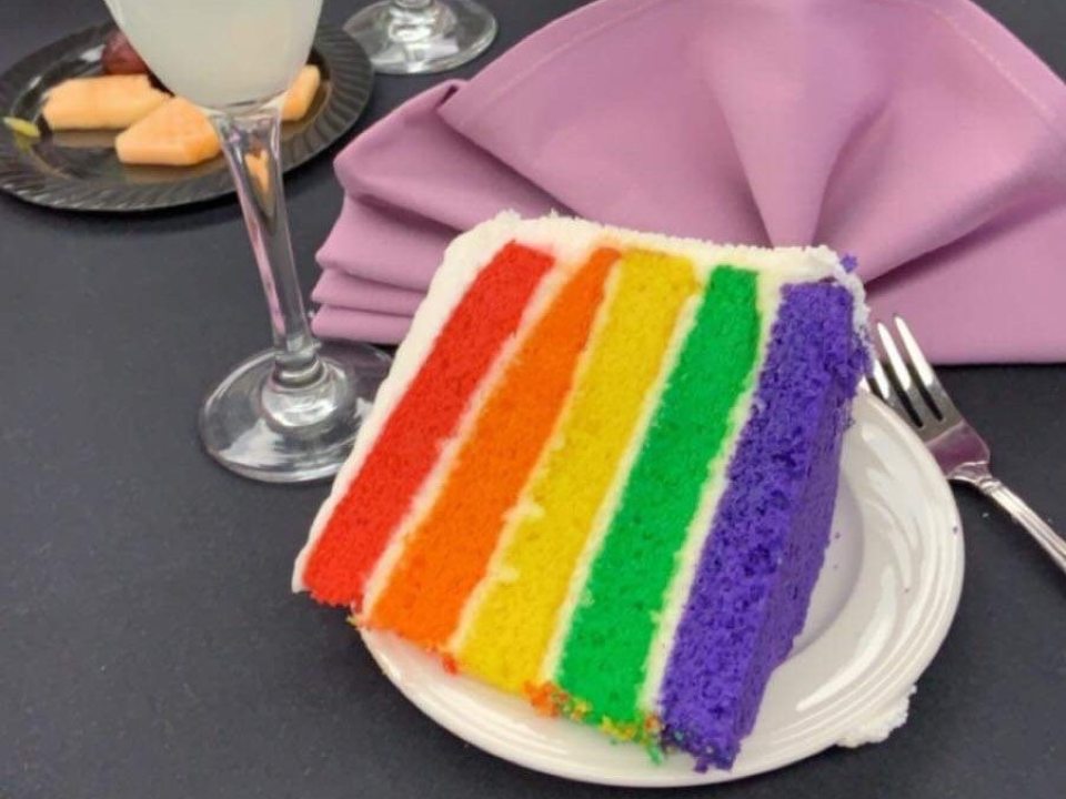 Slice of rainbow layer cake at Lav Grad event.