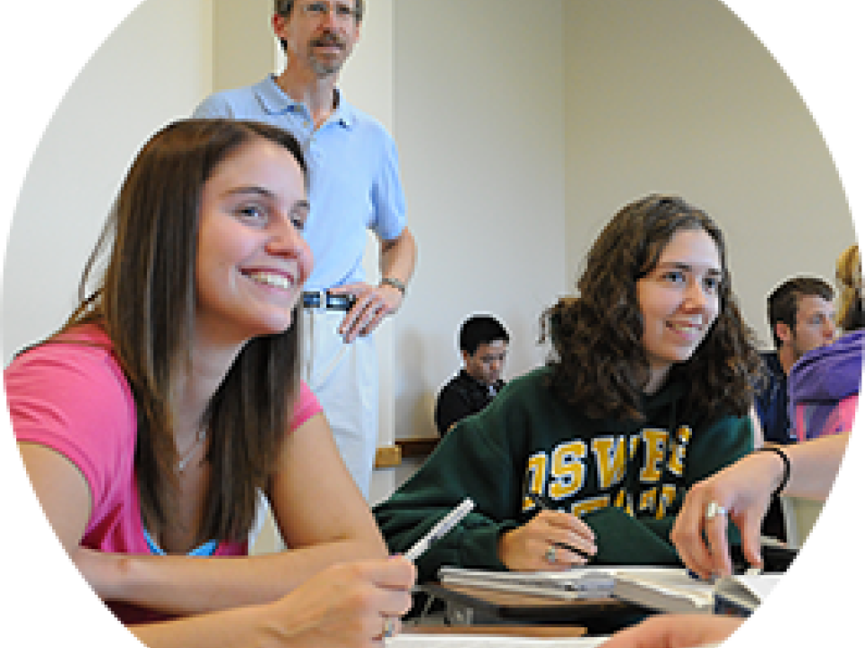 Students and professor in a classroom smiling