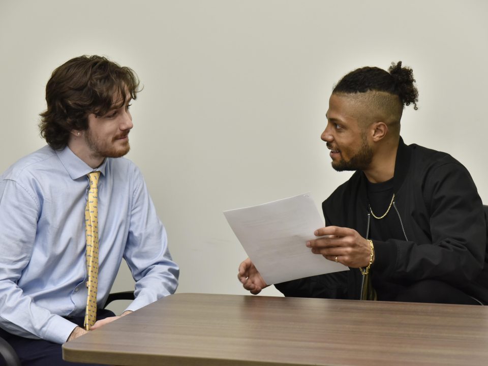 Two people reviewing paperwork together at a table