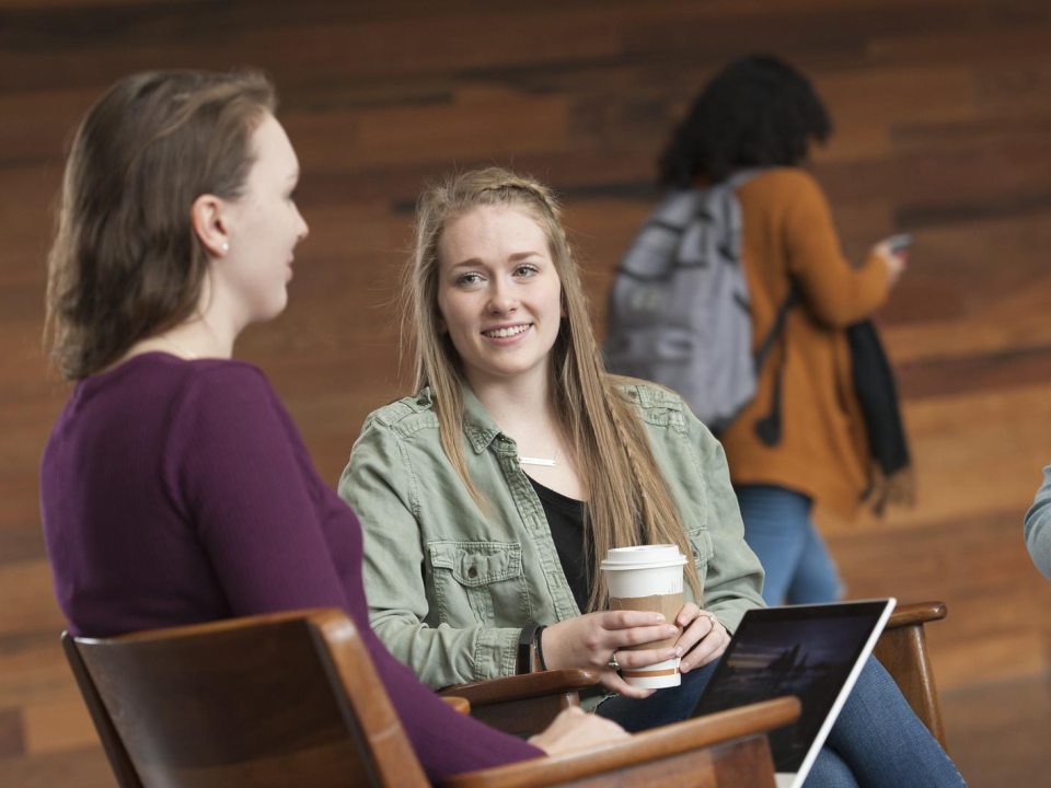 three female students sitting together talking