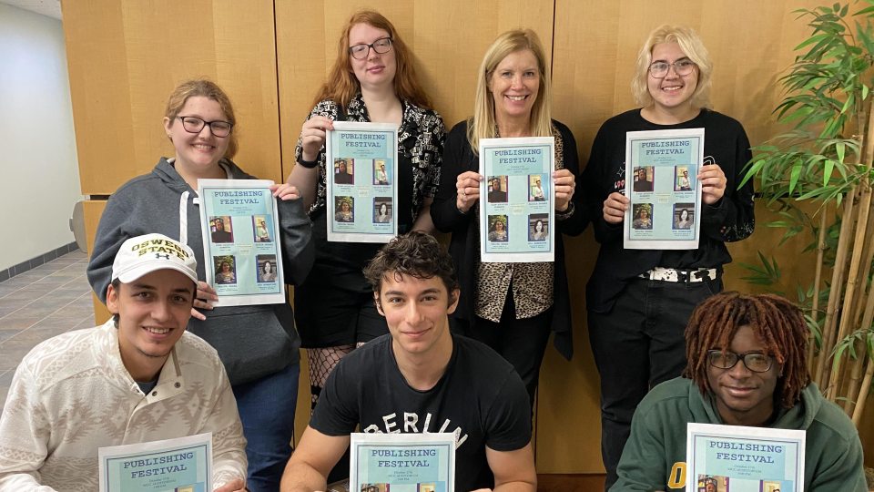 students holding publishing event posters