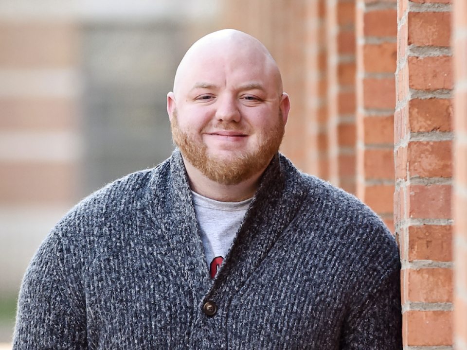 Smiling man with beard in a grey sweater