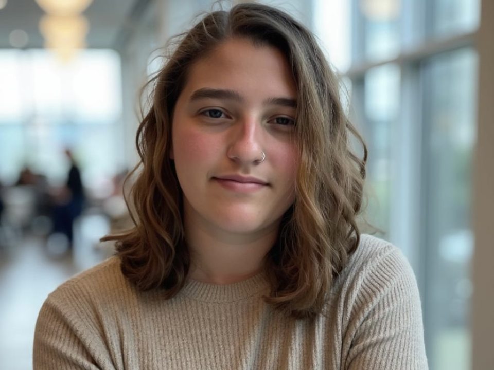 Photo of a person wmiling with shoulder-length brown hair
