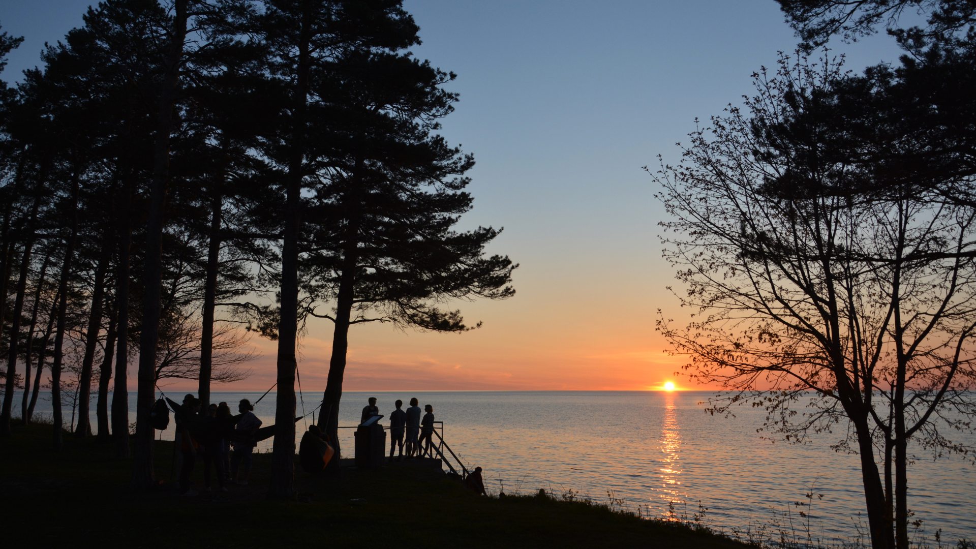 Students watching sunset over lake ontario